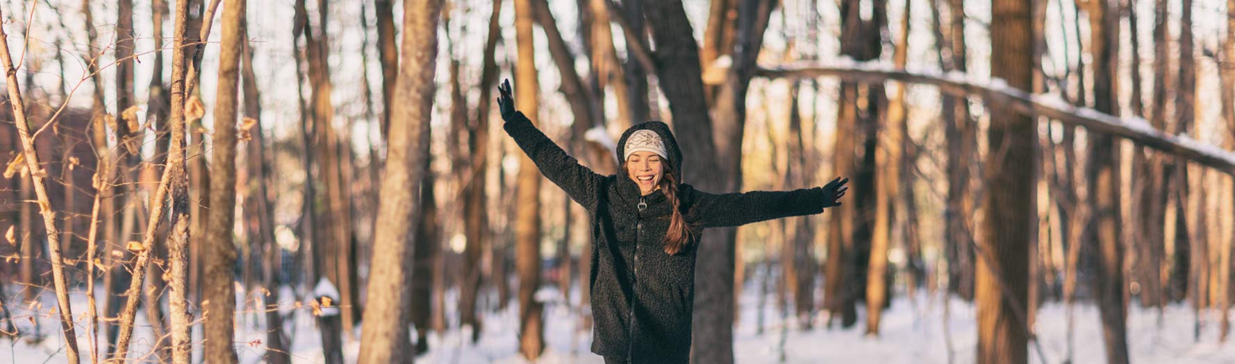 woman smiling walking in winter forest